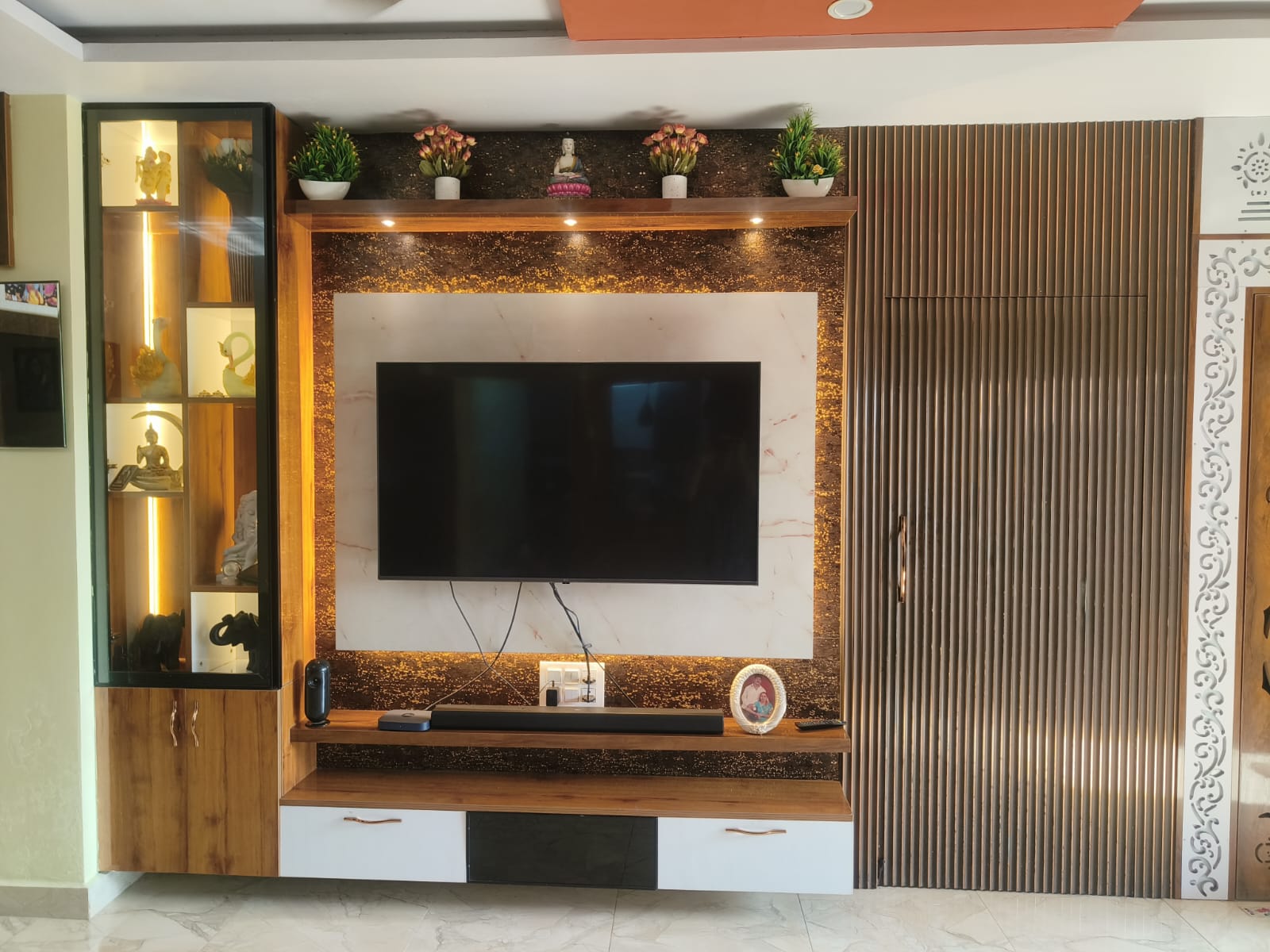 Minimalist TV console showing floating shelves and stone paneling